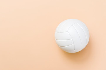 White volleyball leather ball on light brown background. Top view.