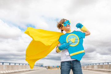 young boy smiling in super hero suit