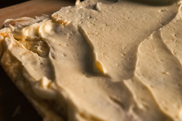 Smearing the cream over the layers of cake dough. Pie filling.