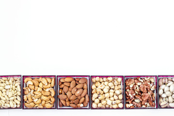 Different types of nuts: peanuts, cashews, almonds, hazelnuts, walnuts and pistachios, horizontal orientation, copy space