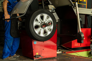Man worker employee with wheel balancing machine.