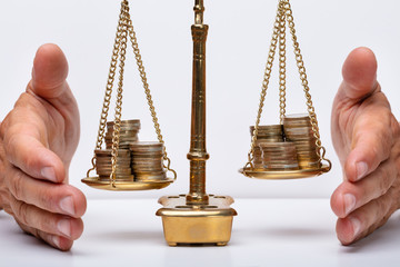 Businessman Protecting Justice Scale With Coins