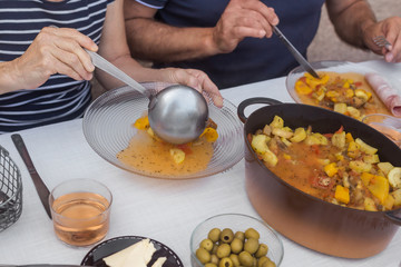 hands of elders couple having dinner together homemade food process of eating white tablecloth