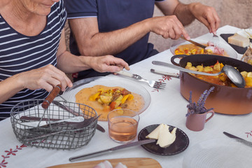 hands of elders couple having dinner together homemade food process of eating white tablecloth