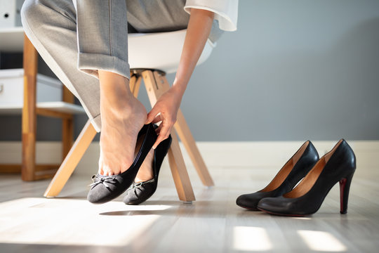 Businesswoman Changing Shoes In Office
