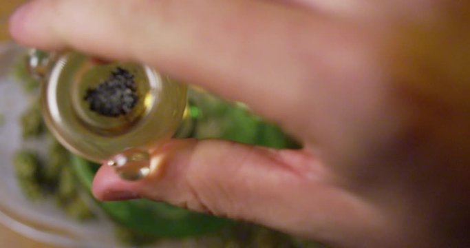 Bowl of marijuana ash is pulled from a large bong, as the smoke is inhaled - extreme closeup - slow motion - shot on RED