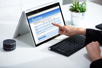 Businesswoman giving online survey on laptop