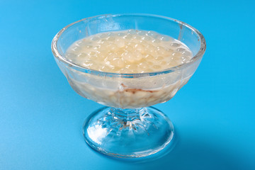 side view bowl of Chinese syrup of sago on blue background