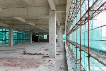 inside of an unfinshed building with protection scaffolding and netting surrounded
