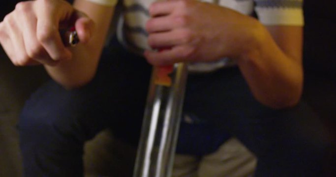 Marijuana brewing in a bong, surrounded by buds and joints - extreme closeup - slow motion - shot on RED