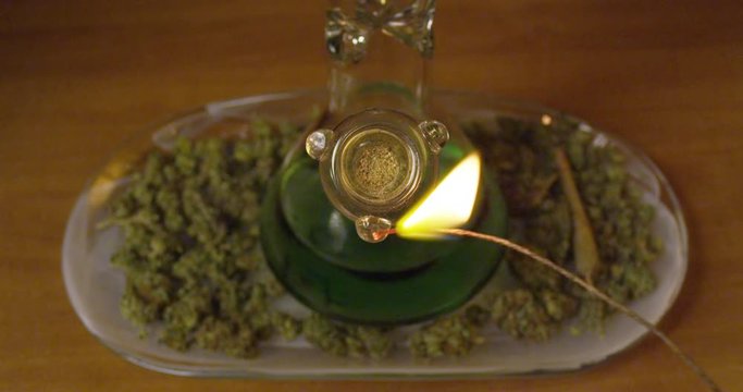 Bowl of marijuana is pulled from a bong, and the smoke is inhaled - extreme closeup - slow motion - shot on RED