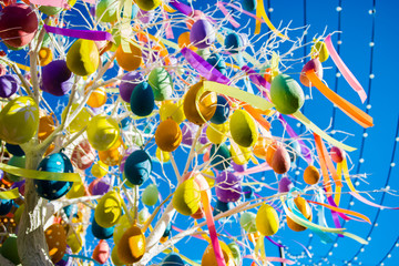 multicolored balloons and ribbons on the tree on blue sky with stripes background. Very colorful,...