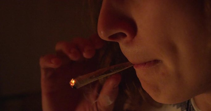 A man inhales from a joint - extreme closeup - slow motion - shot on RED