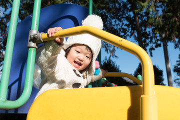 Fototapeta na wymiar Japanese girl playing on a park slide