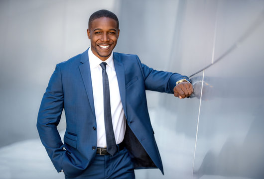 Stylish modern african american business man, handsome smiling portrait next to financial building