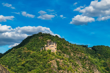 Fototapeta na wymiar View of hilltop castle on the side of Rhine River at beautiful summer day in Germany. Rhine Valley is UNESCO World Heritage Site.