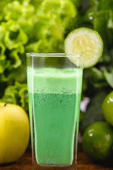 Green smoothie on dark wood background. Healthy smoothie herbal cocktail. Green fruits and vegetables. Healthy food and diet concept.