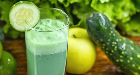 Green smoothie on dark wood background. Healthy smoothie herbal cocktail. Green fruits and vegetables. Healthy food and diet concept.