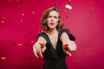 Studio shot of good-looking chilling woman having fun at event with confetti. Indoor portrait of...