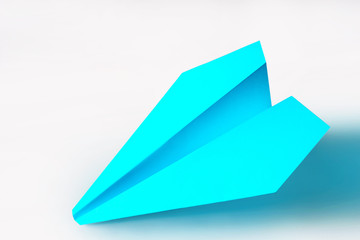 Turquoise paper plane on light background. The concept of rapid movement. Flight. Business leadership. Constant movement. Innovations.