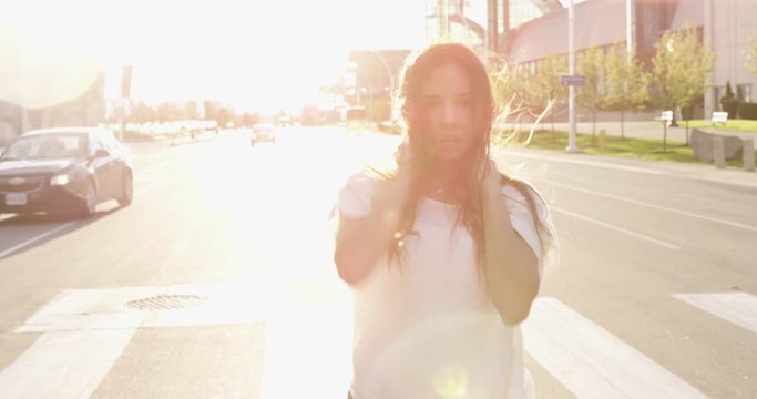 A woman dances hypnotically in the street on a windy day with lensflare - slow motion - shot on RED