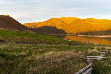 Pasture, hills, and lake during golden hour