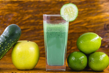 Green smoothie on dark wood background. Healthy smoothie herbal cocktail. Green fruits and vegetables. Healthy food and diet concept.