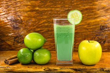 Green smoothie on dark wood background. Healthy smoothie herbal cocktail. Green fruits and vegetables. Healthy food and diet concept.