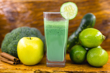 Green smoothie on dark wood background. Healthy smoothie herbal cocktail. Green fruits and vegetables. Healthy food and diet concept.