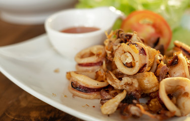 Menu fried sun dried calamari or squid, mixed garlic, served with chili sauce and vegetable, Thai food. Selective focus.