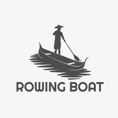 silhouette of a man rowing a small boat