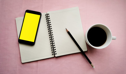 Coffee in white cup with Journal book and smart phone
