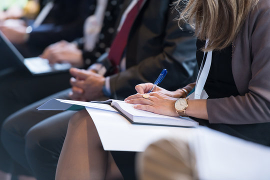 Close Up Of Business People Taking Notes