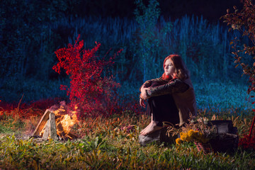 Fototapeta premium young witch by night fire in forest