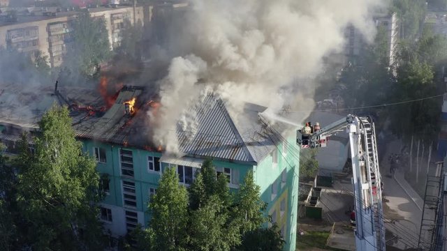 firefighters extinguish a fire on the roof of a residential highrise building. top view