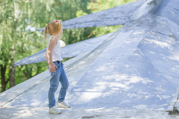 little girl plays in  park on  old metal plane