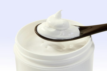 close up of skin care cosmetic beauty cream or lotion in jar and spoon isolated on blur background with Copy space 