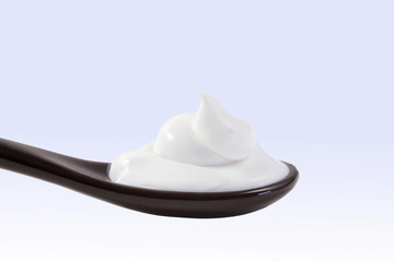 close up of skin care cosmetic beauty cream or lotion in spoon isolated on blur background with Copy space 