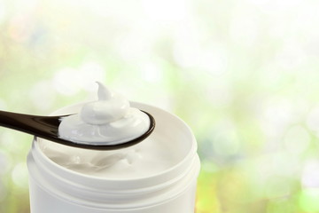 close up of skin care cosmetic beauty cream or lotion in jar and spoon isolated on blur background with Copy space 