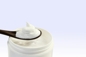 close up of skin care cosmetic beauty cream or lotion in jar and spoon isolated on blur background with Copy space 