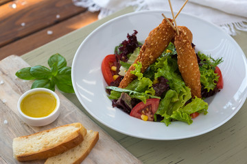 Fried chicken on wooden skewers with vegetable salad and sauce. Spring picnic,,. Delicious lunch. On light background