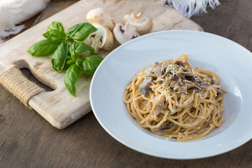 Mushroom Spaghetti Pasta and cream sauce on table, top view. Homemade italian pasta with champignon mushroom