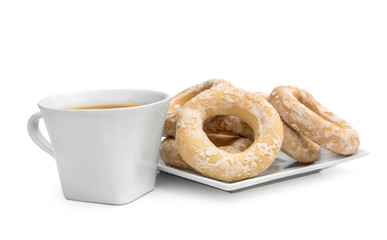 Cup of tea with dried bagels on white.