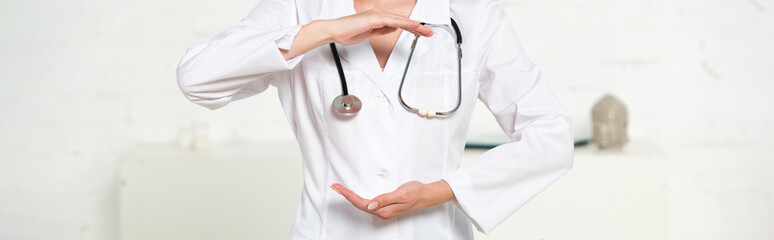 panoramic shot of doctor in white coat with stethoscope gesturing in clinic