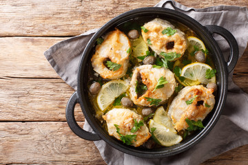 Greek cuisine cod steaks with lemon and olives closeup in a pan. horizontal top view