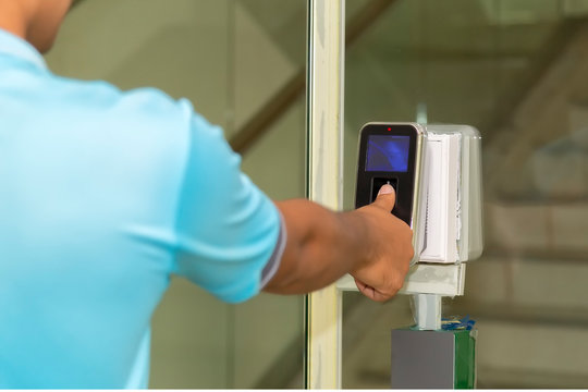 The hand are scanning on fingerprint machine for enter digital security door system in the office building at Bangkok ,Thailand.  Fingerscan with access control on the glass door.