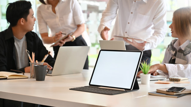 Mockup Tablet Computer On Meeting Room With People Meeting, Empty Screen Tablet.