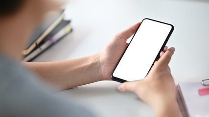 Man holding mockup smartphone on table.