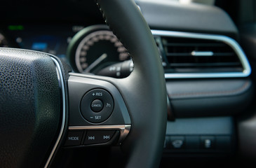 Fototapeta na wymiar Modern car steering wheel with multifunction button of speed cruise control
