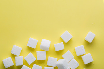 Top view of sugar cube on yellow background. Copy space